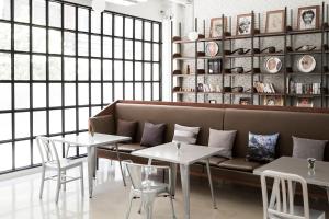 a living room with a couch and two tables at Beat Hotel Bangkok in Bangkok
