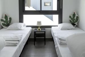 dwa łóżka w pokoju z oknem w obiekcie 3058 Residence Lamar 3058 w mieście Pilar de la Horadada +25 zdjęć