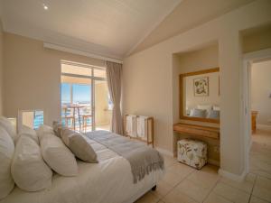 a bedroom with a bed with a view of the ocean at 9 Quarter Deck in St Francis Bay