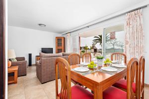 a dining room and living room with a table and chairs at Villas Calan Bosch Olivia in Cala en Bosc