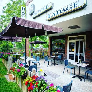 a restaurant with tables and chairs and an umbrella at Hotel Ladage in Frankfurt/Main