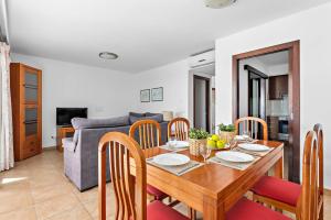 a dining room with a wooden table and chairs at Villas Calan Bosch Emily in Cala'n Bosch