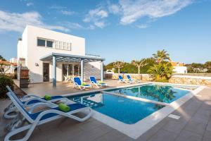 a villa with a swimming pool in front of a house at Villas Calan Bosch Ona in Cala en Bosc
