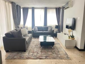 uma sala de estar com um sofá e uma mesa de centro em Luxury @ the Garden em Accra