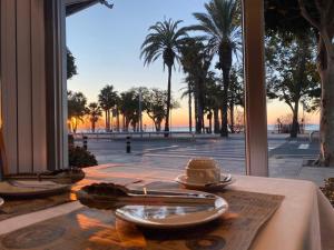 - une table avec une assiette de nourriture et une vue sur la plage dans l'établissement Hotel Rovira, à Cambrils