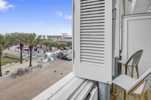 a balcony with a bench and a view of a street at Beach and Gulf Views from the Center of Seaside! condo in Santa Rosa Beach