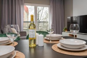 a bottle of wine sitting on a table with glasses at CityCenterApartments-11/19 in Bielsko-Biala
