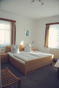 um quarto com uma cama grande e lençóis brancos em Pension Morgenweck em Bad Salzungen