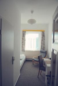 um quarto com uma cama, uma cadeira e uma janela em Pension Morgenweck em Bad Salzungen