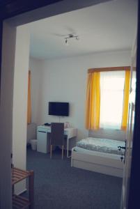 Schlafzimmer mit einem Bett und einem Schreibtisch mit einem Computer in der Unterkunft Pension Morgenweck in Bad Salzungen