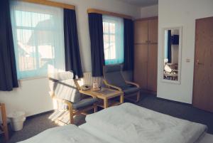 Habitación con 1 cama, 2 sillas y mesa. en Pension Morgenweck en Bad Salzungen