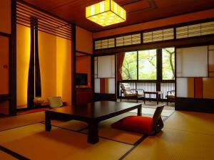 a living room with a coffee table and a room with a balcony at Sanrakuen in Tonami