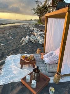 - une tente sur la plage avec un plateau de nourriture dans l'établissement Le Temps d'Aime, à Le Bois de Nèfles