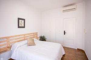 1 dormitorio con cama blanca y puerta blanca en Hostal Rio, en Medellín