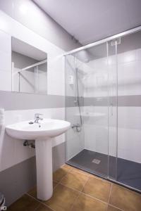 a bathroom with a sink and a glass shower at Hostal Rio in Medellín