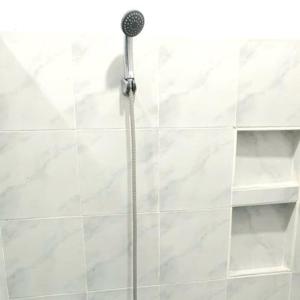 a shower with a shower head in a bathroom at Spacious Resort in Pansol up to 20 pax in Pansol