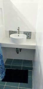 baño con lavabo blanco y azulejos verdes en Spacious Resort in Pansol up to 20 pax, en Pansol
