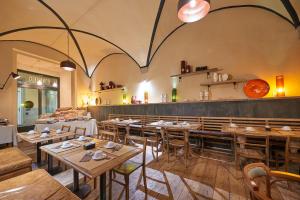 ein Restaurant mit Holztischen und -stühlen und einer Bar in der Unterkunft TAILOR HOUSE B&B in Florenz