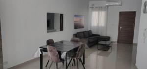 a living room with a table and chairs and a couch at Seron Apartment 3 in St. Paul's Bay