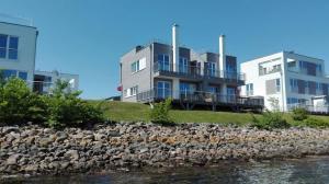 a house on top of a hill next to the water at Haus Hafenblick in Olpenitz