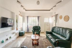 salon z zieloną kanapą i stołem w obiekcie North Manor Nakuru w mieście Nakuru
