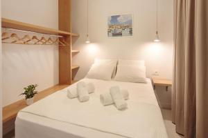 a bedroom with a white bed with white towels on it at Terpsis Estate in Chania