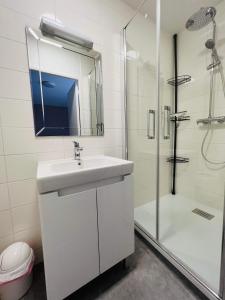 a white bathroom with a sink and a shower at Le Cigano 