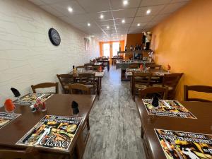 a dining room with tables and chairs and a clock on the wall at Le Cigano 