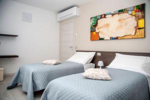 um quarto com duas camas e um quadro na parede em Camelot Red - Appartamenti em Verona