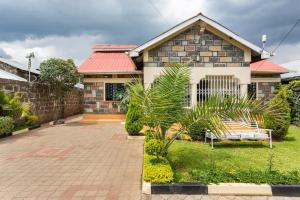 una casa con un banco delante de ella en North Manor Nakuru en Nakuru