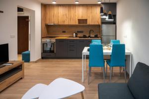 a kitchen with a dining table and blue chairs at Modern and Cozy 1BDR Apartment in the City Center in Sofia