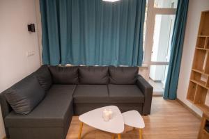 a living room with a couch and a table at Modern and Cozy 1BDR Apartment in the City Center in Sofia