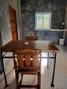 una mesa de madera con 2 sillas y una ventana en Lanta Farita House, en Phra Ae beach