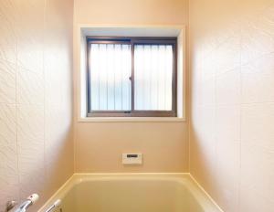 a bath tub in a bathroom with a window at The Domain in Kochi