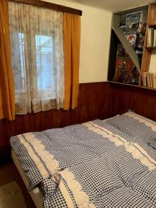 a bed sitting in a bedroom with a window at Retro chata na Čupku in Metylovice