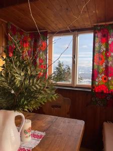 a table with a christmas tree in a room with windows at Retro chata na Čupku in Metylovice