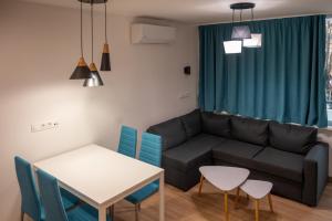 a living room with a couch and a table and chairs at Modern and Cozy 1BDR Apartment in the City Center in Sofia