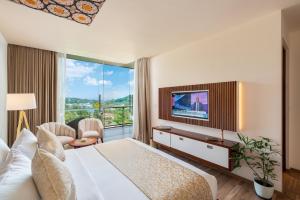 een hotelkamer met een groot bed en een televisie bij Grand Serendib Hotel in Kandy