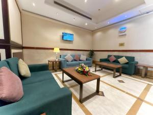 a waiting room with blue couches and a table at Al Massa Bader Hotel in Makkah