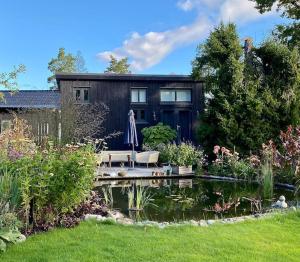 a house with a pond in front of it at Orres Guesthouse Stenhamra, Ekerö in Stenhamra