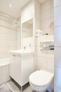 La salle de bains blanche est pourvue de toilettes et d'un lavabo. dans l'établissement Grzybowska 16/22 by Homeprime, à Varsovie