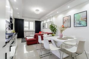 a kitchen and living room with a white table and chairs at Lumina 3 bedroom apart Park Szczęśliwicki in Warsaw