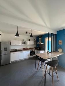 een keuken met blauwe muren en een houten tafel bij Superbe appartement centre ville in Nîmes