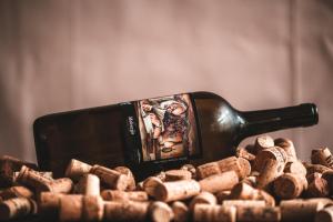a bottle of wine sitting on top of a pile of wine corks at Hotel Hvala Superior - Topli Val in Kobarid