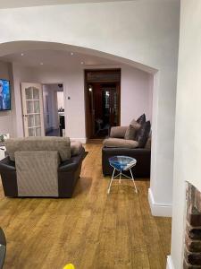 a living room with two couches and a table at Green Villa in Hickleton