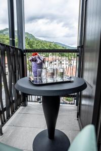 a table on a balcony with a tray of glasses at Hotel Hvala Superior - Topli Val in Kobarid