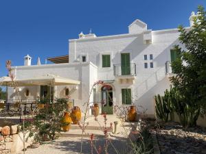 una casa bianca con delle piante davanti di Boutique Hotel Masseria Sottomasi a Savelletri