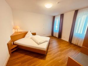 1 dormitorio con cama, mesa y ventanas en Serviced Apartments Hohenlohe, 