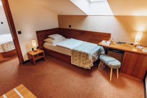 a hotel room with a bed and a desk and a bed sidx sidx sidx sidx at Hotel Hvala Superior - Topli Val in Kobarid
