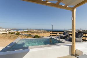 a swimming pool with a view of the ocean at Maisonette Sail in Naousa